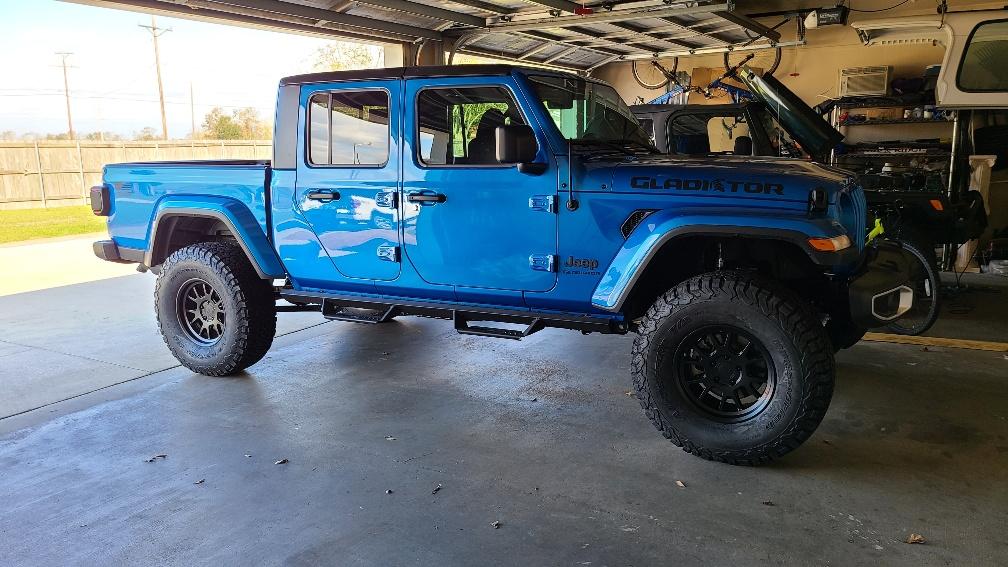 Jeep Gladiator Bruiser...hydro blue and black sport s diesel. after tires in garage
